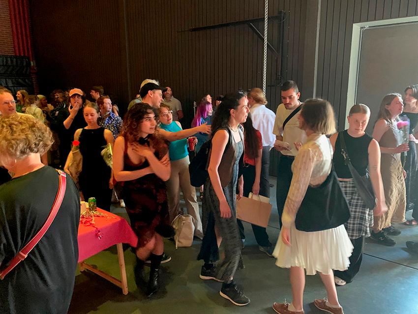 Festklädda studenter minglar på examensceremoni